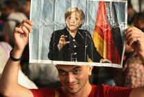 上万难民抵达德国 入境高举默克尔照片