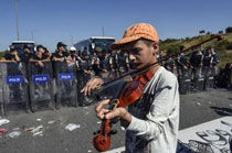 13岁小难民在警察盾牌阵前拉小提琴