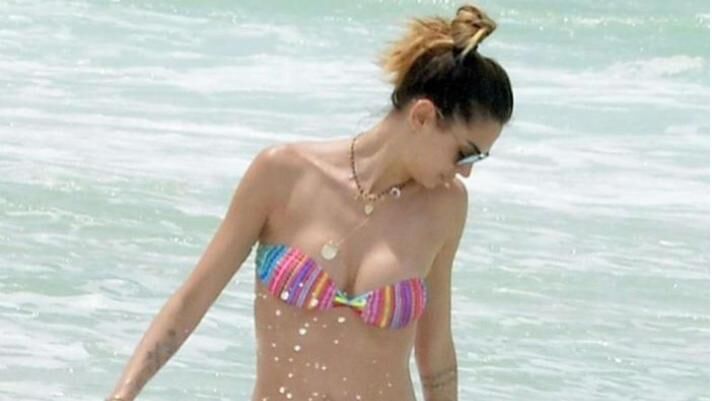 超模梅丽莎.萨塔，穿彩色泳装戏水，笑容洋溢